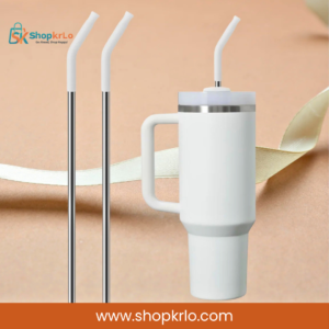 Long stainless steel reusable straw shown beside a large white travel tumbler
